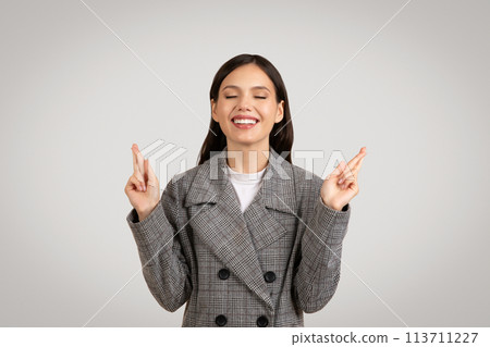 Joyful businesswoman with fingers crossed, wishing or hoping with big smile Joyful businesswoman with fingers crossed, wishing or hoping with big smile 113711227