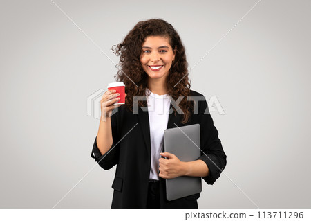 Smiling professional woman with coffee and laptop Smiling professional woman with coffee and laptop 113711296