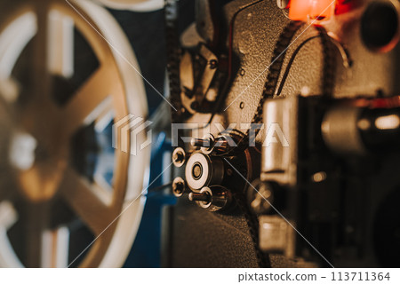 Vintage 8mm film projector, rotating reels. Nostalgic charm of classic cinema. 113711364