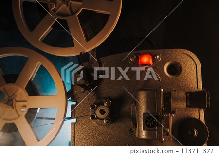 White film reels rotating.Old-fashioned 8mm movie projector playing bobbin tape White film reels rotating.Old-fashioned 8mm movie projector playing bobbin tape 113711372