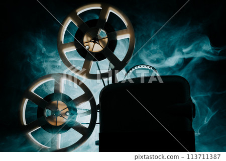 Retro projector playing motion picture. dark room. Timeless flicker of old films 113711387
