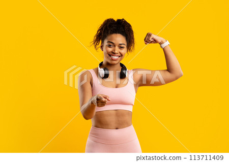 Smiling african american woman with fists up in fitness pose Smiling african american woman with fists up in fitness pose 113711409