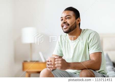 Smiling black man enjoying morning at home Smiling black man enjoying morning at home 113711451