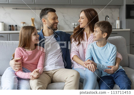 Happy family sitting together on a couch Happy family sitting together on a couch 113711453