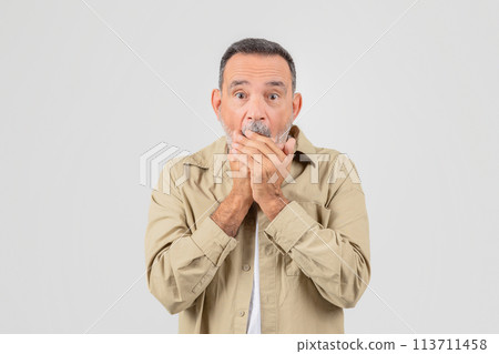 Elderly man covering mouth in surprise on white Elderly man covering mouth in surprise on white 113711458