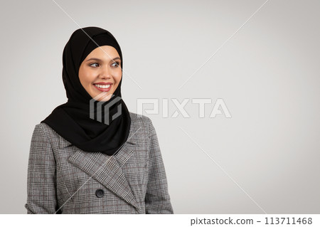 Smiling professional woman in hijab and plaid suit Smiling professional woman in hijab and plaid suit 113711468