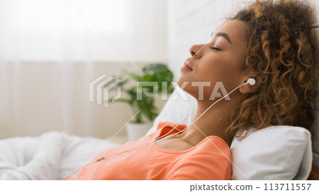 African-american woman listening calm music and relaxing African-american woman listening calm music and relaxing 113711557