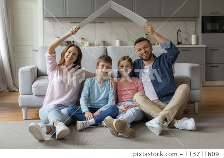 Family creating a house shape with arms and paper board Family creating a house shape with arms and paper board 113711609