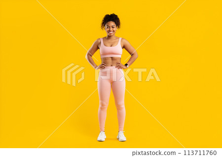 Black lady standing in fitness gear smiling Black lady standing in fitness gear smiling 113711760