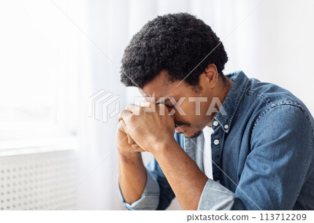 Young Black Man Expressing Frustration Indoors During Daytime Young Black Man Expressing Frustration Indoors During Daytime 113712209