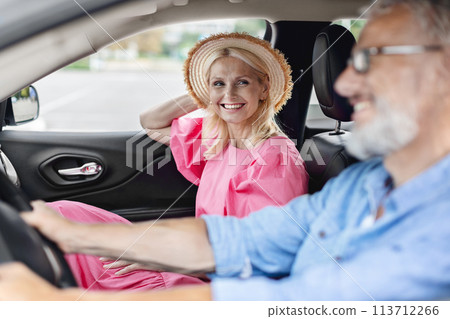 Smiling elderly couple in car after shopping 113712266