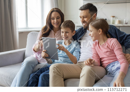 Family gathered around a digital tablet, home interior 113712271