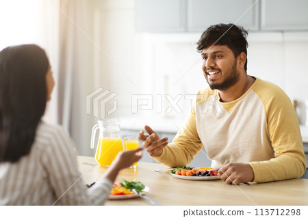 Cheerful millennial indian man have breakfast with his girlfriend Cheerful millennial indian man have breakfast with his girlfriend 113712298