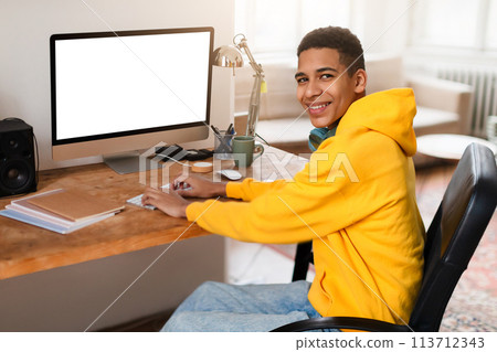 Young man with headphones at computer workstation 113712343