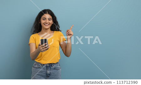 Smiling woman with phone making gesture 113712390