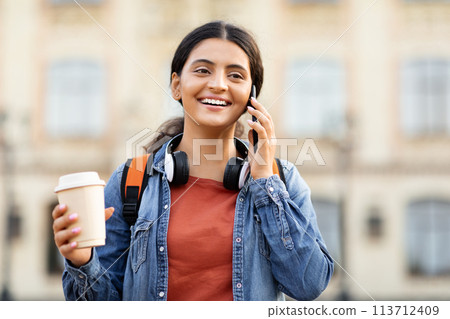 Indian student talking on phone with coffee 113712409