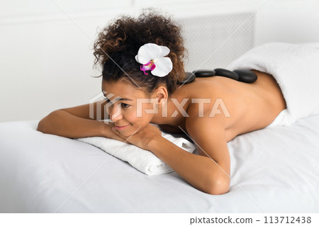 Woman enjoying stone massage, relaxing in spa Woman enjoying stone massage, relaxing in spa 113712438