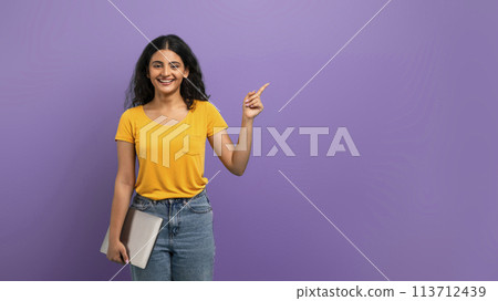Smiling woman pointing up and holding tablet Smiling woman pointing up and holding tablet 113712439
