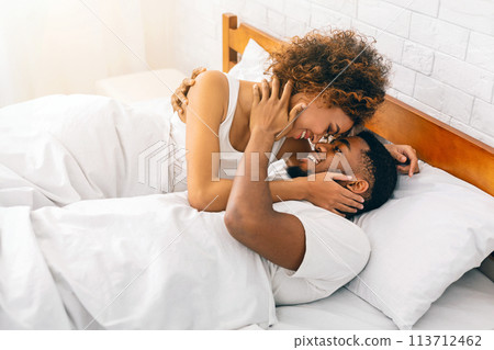 Couple happily cuddling in bed at home 113712462