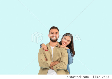 Happy couple posing with a hug on blue background 113712484