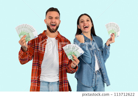 Happy couple holding cash together on blue background 113712622