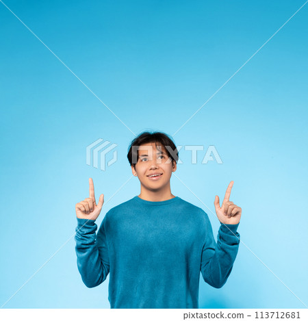 Asian guy looking up with fingers pointing upwards 113712681