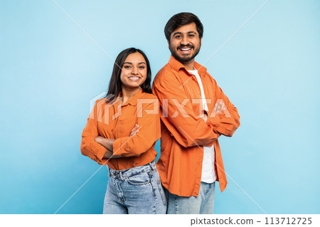 Two people posing confidently together on blue Two people posing confidently together on blue 113712725