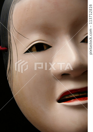 A Noh mask with gold paint on the eyes and teeth, trying to suppress jealousy. A Noh mask with gold paint on the eyes and teeth, trying to suppress jealousy. 113712816
