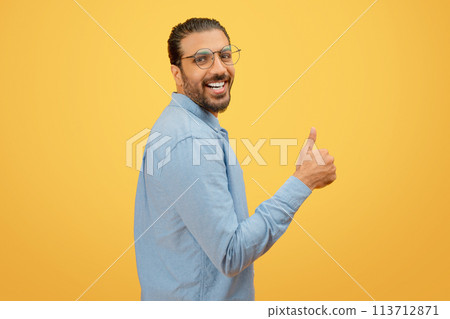 Man giving a thumbs up with a cheerful expression 113712871