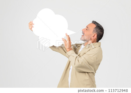 Man holding a blank white speech bubble 113712948