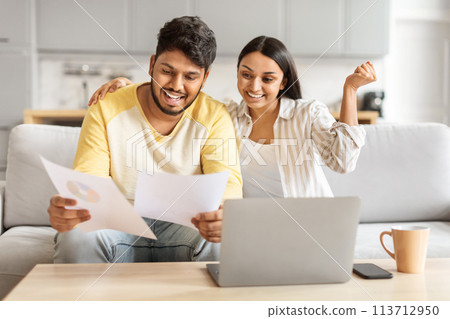 Happy couple analyzing financial documents at home 113712950