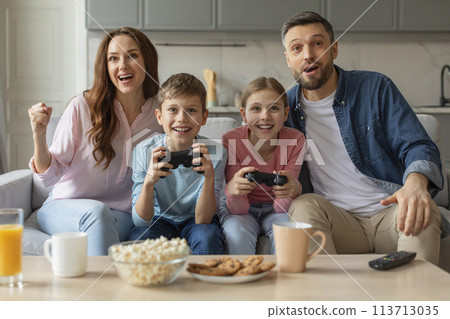 Family engaged in an intense video game session 113713035