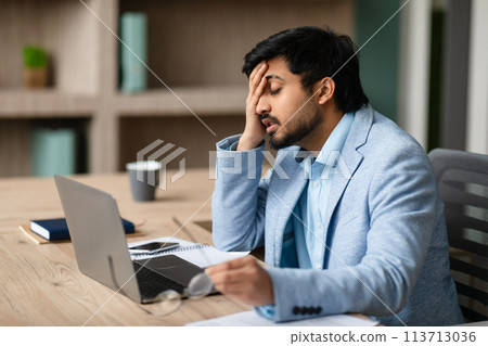 Exhausted Middle Eastern Businessman Touching Face Sitting At Laptop Indoor 113713036