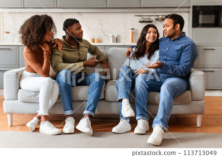 Friends talking and relaxing on a sofa Friends talking and relaxing on a sofa 113713049