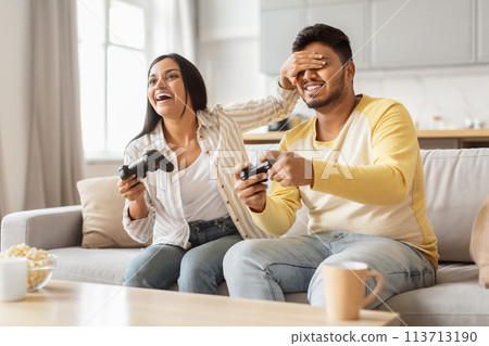 Happy couple playing video games together at home 113713190