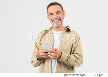 Smiling older man with smartphone in hand 113713259