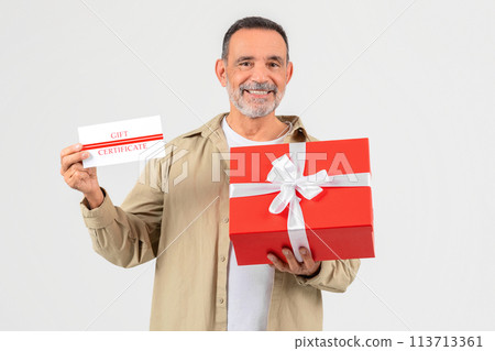Smiling man holding gift certificate and box 113713361
