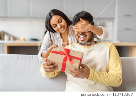 Surprise Gift Presentation by Smiling Indian Woman to Man at Home Surprise Gift Presentation by Smiling Indian Woman to Man at Home 113713367