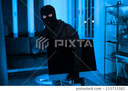 Burglar carrying a stolen TV in the dark night Burglar carrying a stolen TV in the dark night 113713382