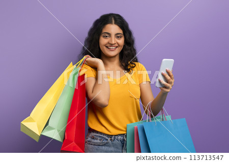 Happy shopper with colorful bags and phone 113713547