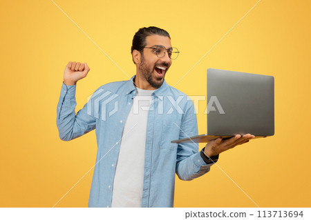 Happy man celebrating with laptop 113713694