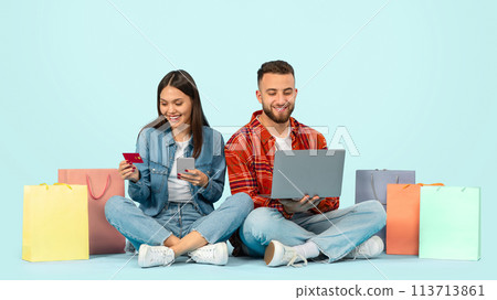 Happy buyers couple shopping online on phone and laptop, studio 113713861