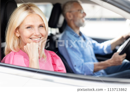 Smiling woman passenger with man driver, spouses traveling together Smiling woman passenger with man driver, spouses traveling together 113713862