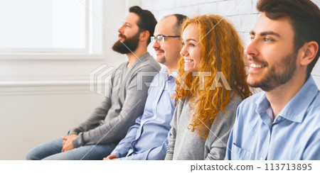 Happy people sitting in a row and listening speaker during workshop Happy people sitting in a row and listening speaker during workshop 113713895
