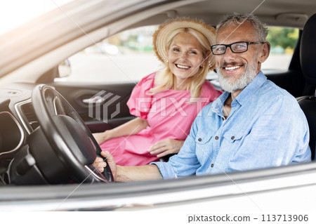 Happy elderly couple in car with window down Happy elderly couple in car with window down 113713906