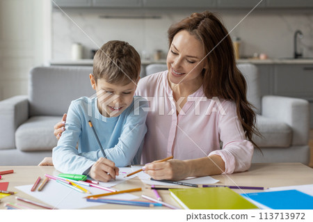 Mother enjoying artwork with her son at home 113713972