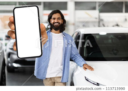 Man showcasing smartphone at car dealership 113713990
