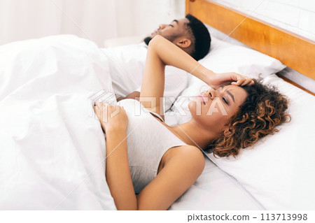 Unhappy woman having sleepless night with snoring man Unhappy woman having sleepless night with snoring man 113713998