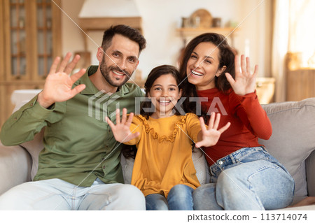Family happily waving at the camera at home Family happily waving at the camera at home 113714074