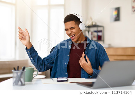 Black teen boy enjoying music, singing, imaging playing guitar 113714104